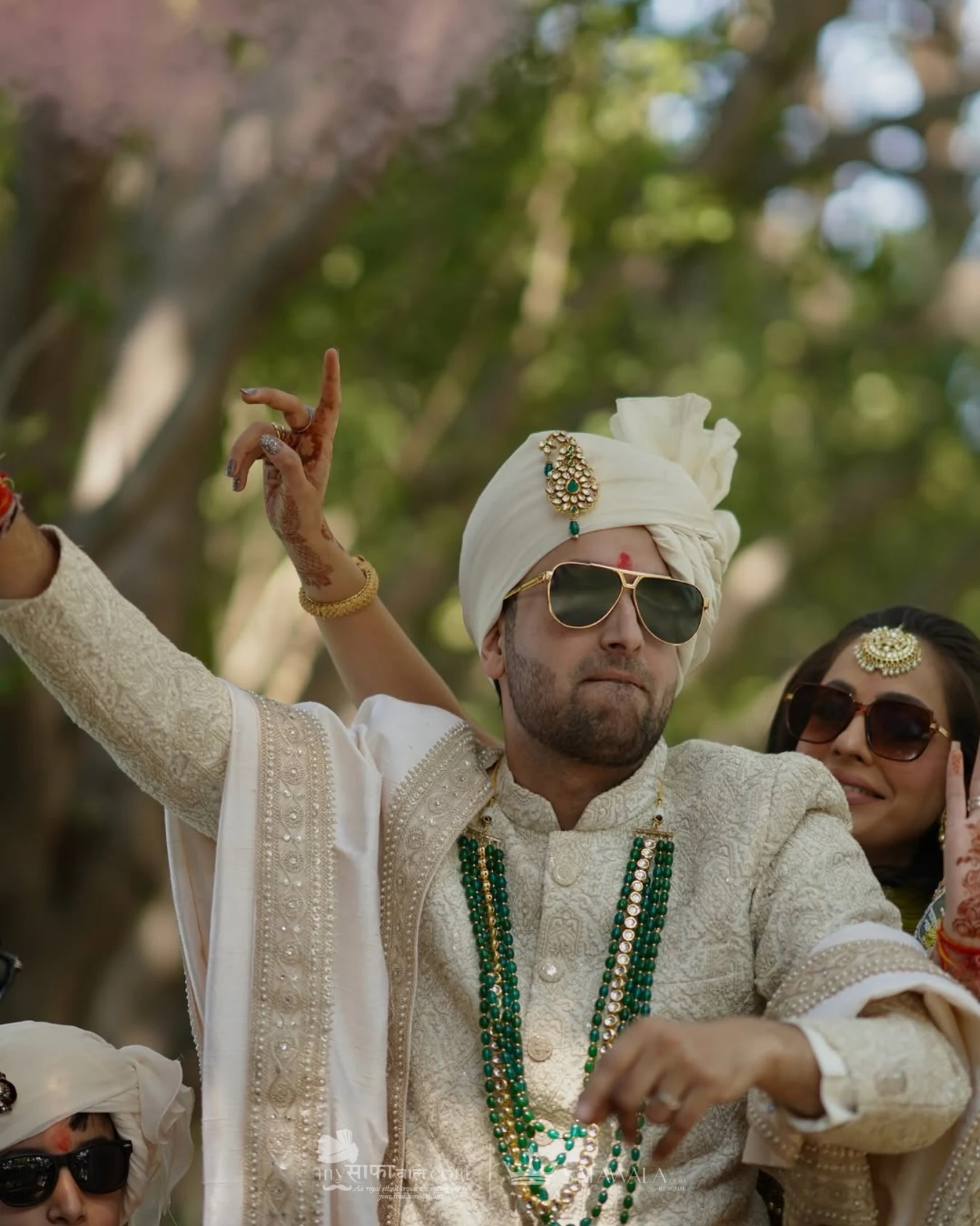 Groom in an ivory wedding safa with emerald jewellery for Vake